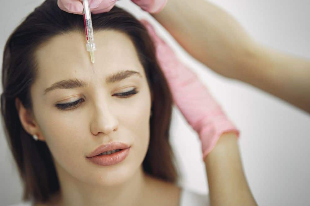 Medical professional administering Botox injection for chronic migraine prevention in clinic