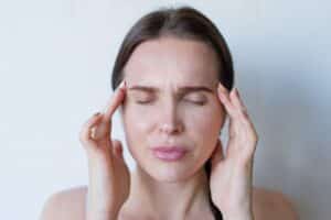 Woman pressing temples in pain, seeking chronic migraine relief in Grand Prairie TX