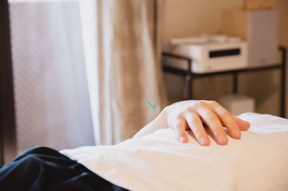 Patient resting comfortably in pain clinic treatment room after outpatient procedure