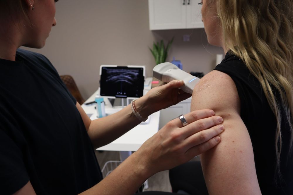 Physical therapist administering shockwave therapy for chronic musculoskeletal pain