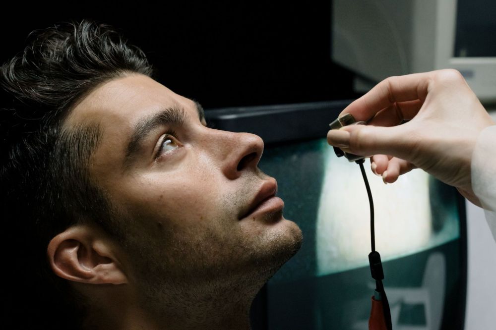 Eye doctor examining patient for dry eye symptoms related to chronic pain