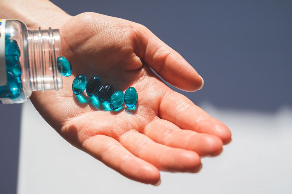 Melatonin & Botox for Chronic Migraines in Grand Prairie, TX 1 Melatonin supplement capsules on a nightstand beside a glass of water