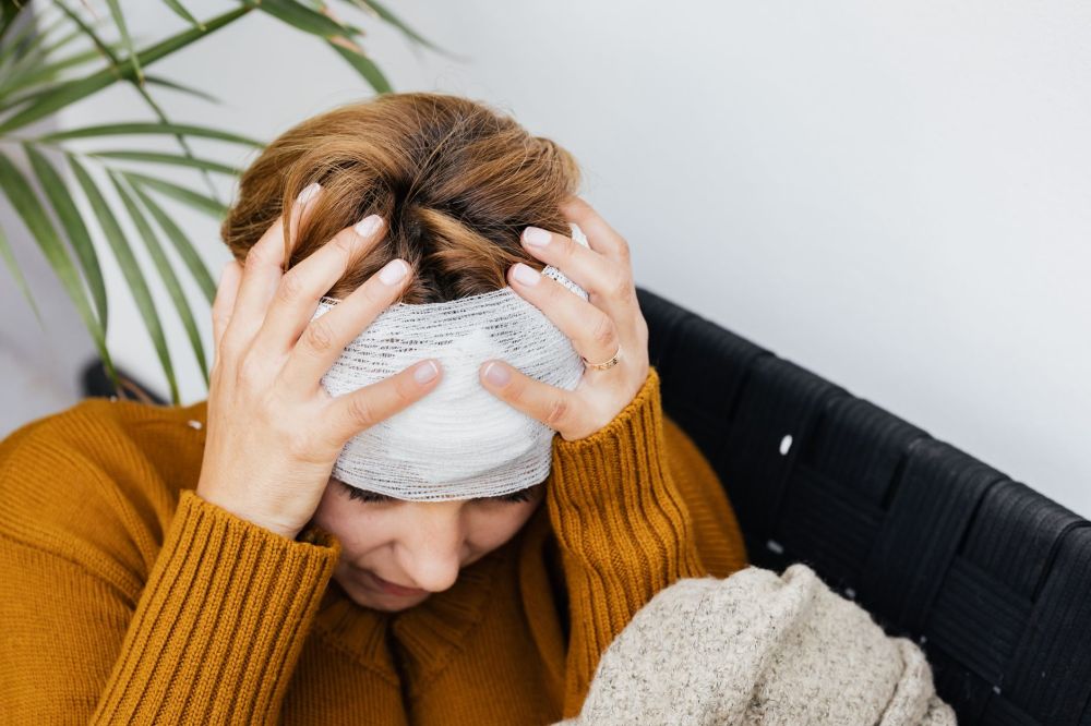 Adult holding temples in pain suggesting chronic tension headache or migraine symptoms