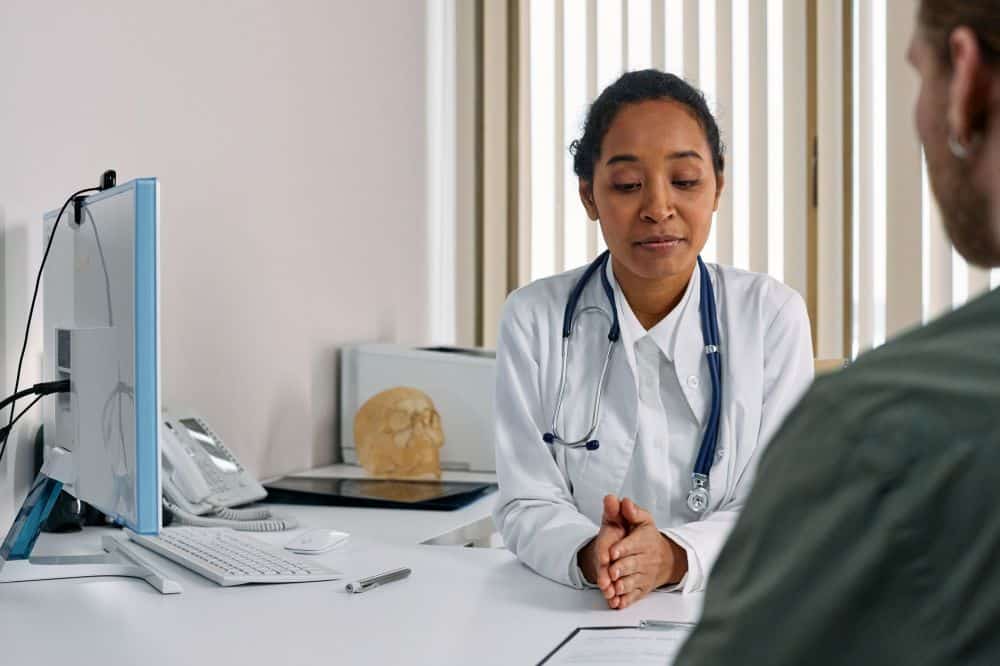 Pain management doctor consulting patient about migraine treatment options in clinic