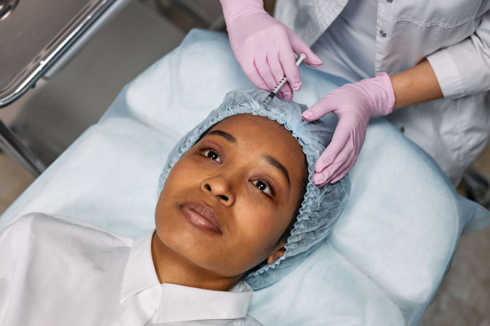 Medical professional administering Botox injection to patient's forehead for chronic migraine relief