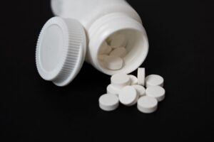 Melatonin supplement capsules beside a sleep mask suggesting chronic pain and sleep relief