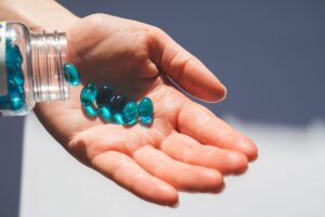 Melatonin supplement capsules beside a glass of water for chronic pain relief