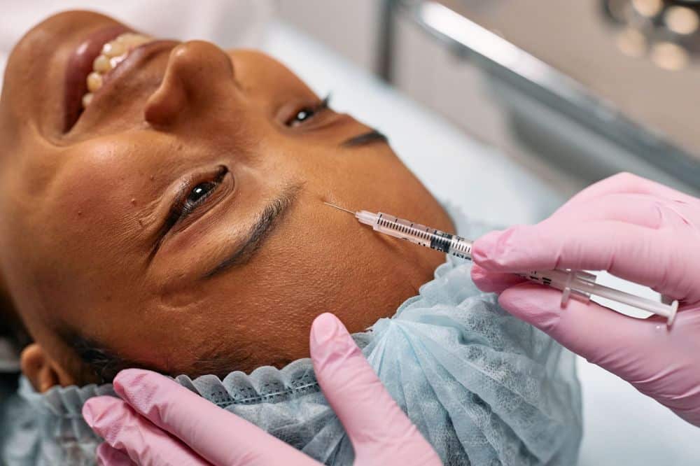 Medical professional administering Botox injection for chronic migraine treatment