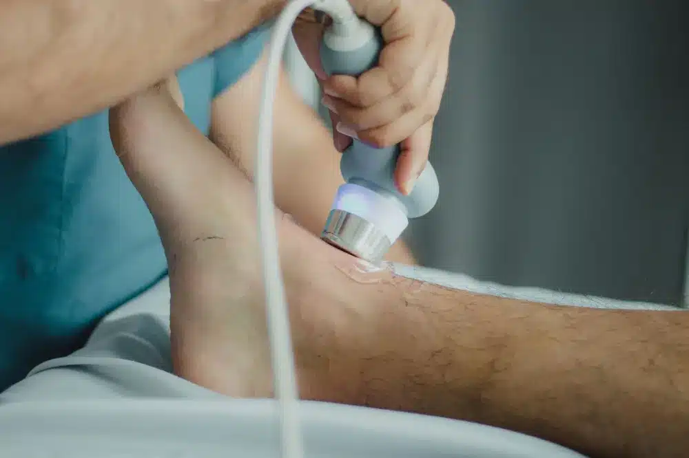 Clinician performing an ultrasound-guided hip injection on a patient in a procedure room