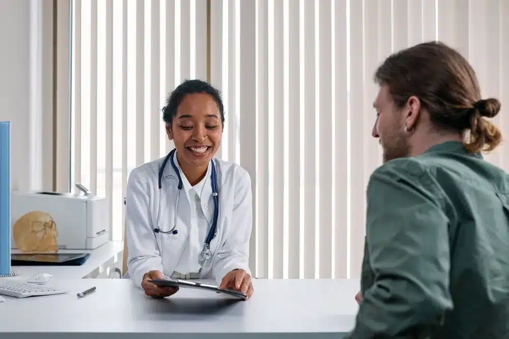 Pain management doctor reviewing spine imaging with a patient during a back pain consultation