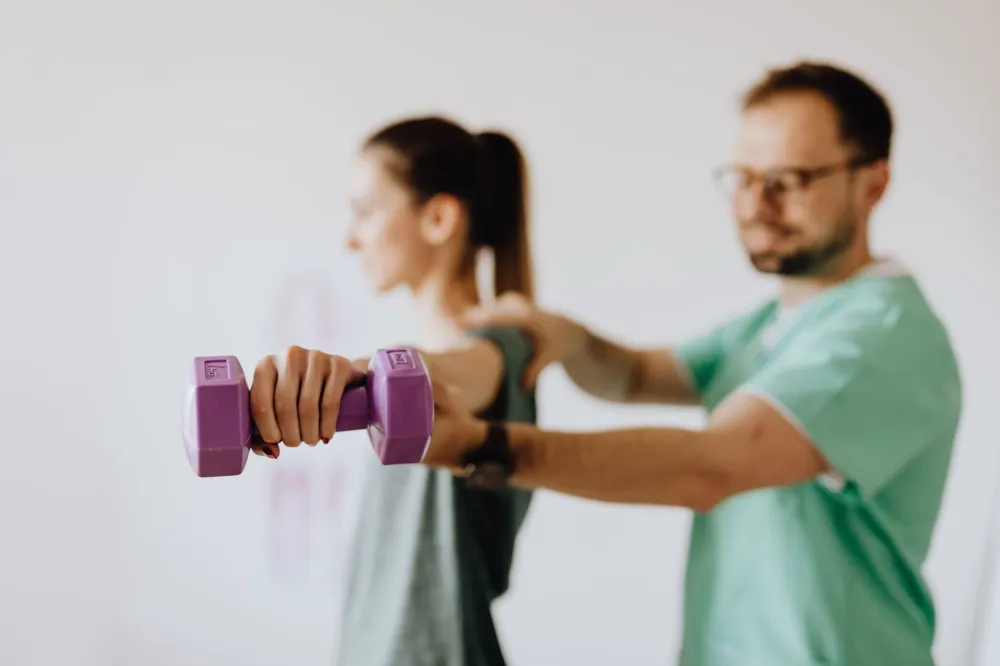 Patient doing physical therapy exercises for shoulder tendon injury recovery